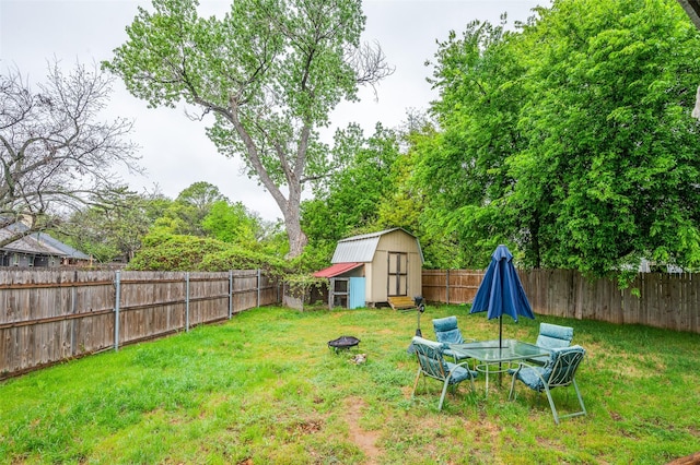 view of yard featuring a storage unit, a fenced backyard, and an outdoor structure