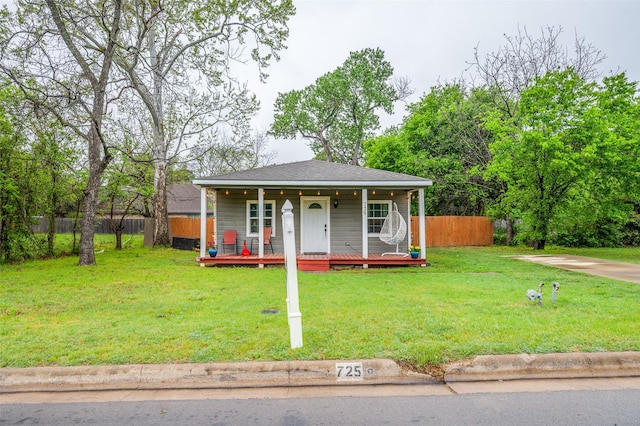bungalow featuring a shingled roof, fence, a front yard, and a porch