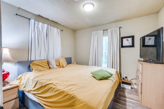 bedroom featuring wood finished floors and a textured ceiling