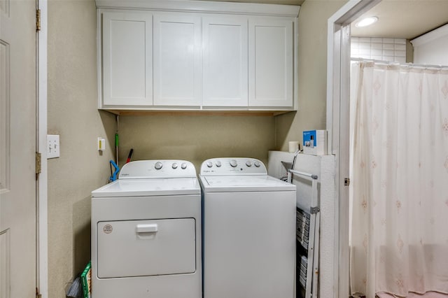washroom featuring washer and dryer and cabinet space