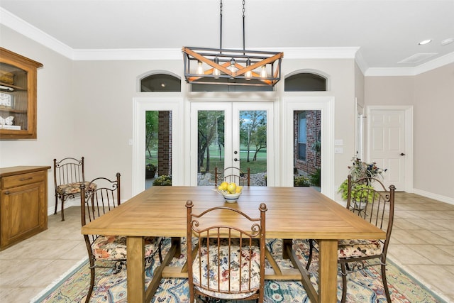 dining space featuring a chandelier, ornamental molding, french doors, baseboards, and light tile patterned flooring