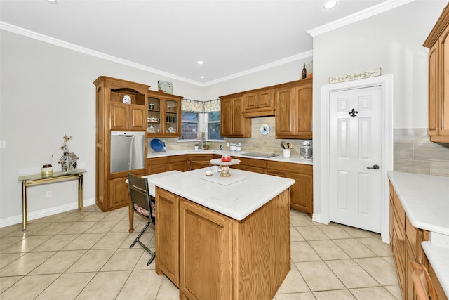 kitchen with black electric stovetop, decorative backsplash, light tile patterned floors, light countertops, and a kitchen island