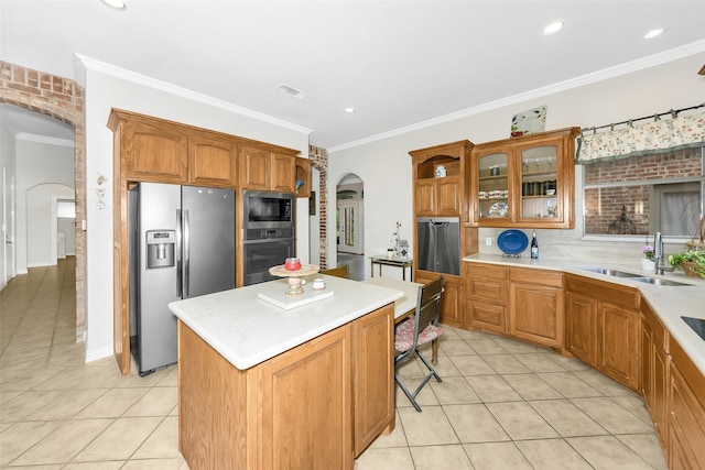 kitchen with light tile patterned floors, arched walkways, a sink, and stainless steel appliances