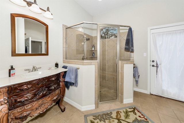 bathroom featuring tile patterned flooring, a shower stall, vaulted ceiling, vanity, and baseboards