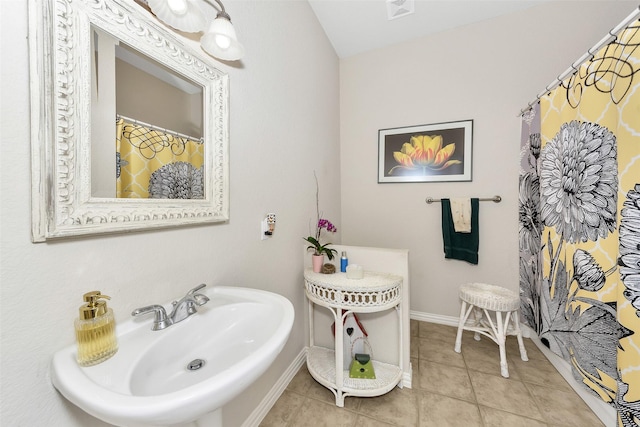 bathroom featuring baseboards, visible vents, tile patterned flooring, and a sink
