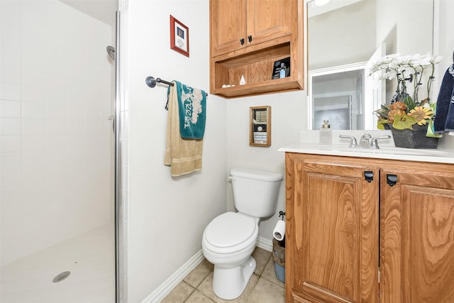 bathroom with tiled shower, tile patterned flooring, toilet, vanity, and baseboards