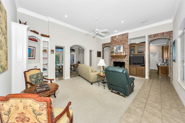 living room featuring recessed lighting, arched walkways, light tile patterned floors, ornamental molding, and ceiling fan