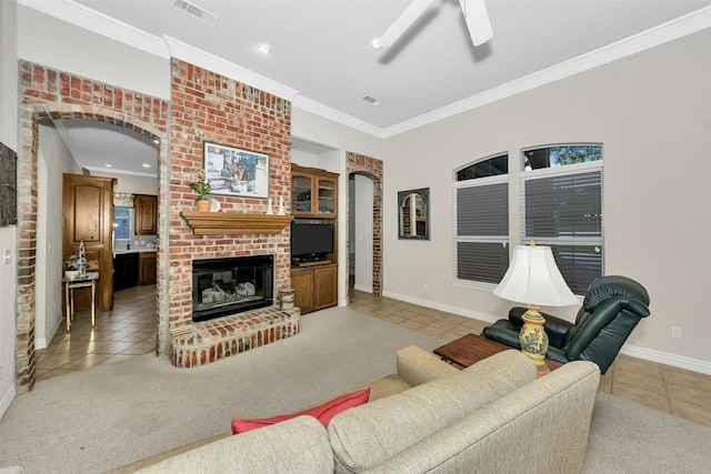 living room featuring light tile patterned floors, a brick fireplace, visible vents, baseboards, and arched walkways