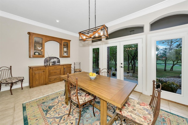 dining space featuring a chandelier, light tile patterned floors, baseboards, french doors, and crown molding