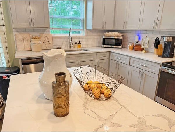 100 Winchester Cir, Gun Barrel City, TX 75156 - kitchen with gray cabinetry, backsplash, a sink, and stainless steel appliances