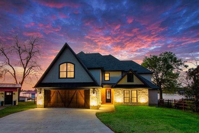 view of front of home with stone siding, fence, a front lawn, and concrete driveway