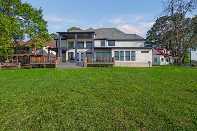 back of house with a deck, french doors, and a yard