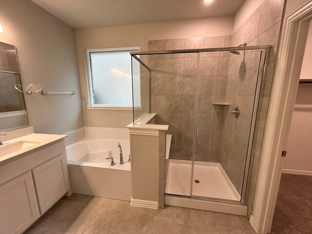 full bath with vanity, tile patterned floors, a garden tub, and a stall shower