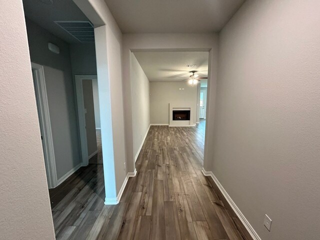 hallway featuring visible vents and baseboards