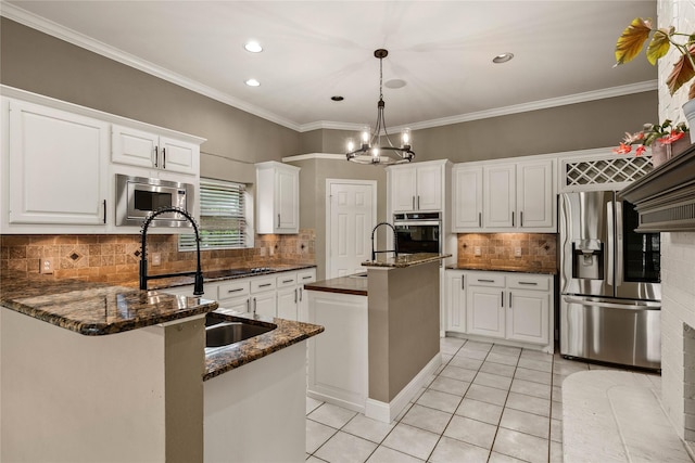 kitchen featuring light tile patterned floors, white cabinets, a sink, an island with sink, and stainless steel appliances