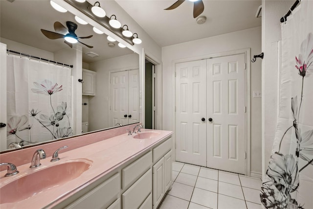full bath featuring double vanity, a sink, a ceiling fan, and tile patterned flooring