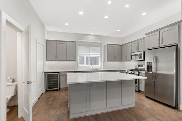 4914 Live Oak St Unit 7, Dallas, TX 75206 - kitchen with appliances with stainless steel finishes, gray cabinetry, wine cooler, a sink, and a center island