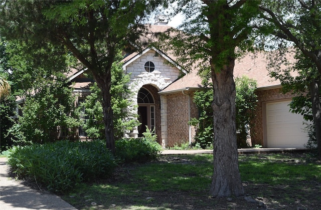 2515 Cambridge Dr, Heath, TX 75032 - view of property hidden behind natural elements featuring a garage, a chimney, and stone siding