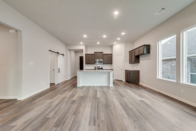 3523 Columbus St, Gainesville, TX 76240 - kitchen featuring appliances with stainless steel finishes, a barn door, healthy amount of natural light, light countertops, and recessed lighting