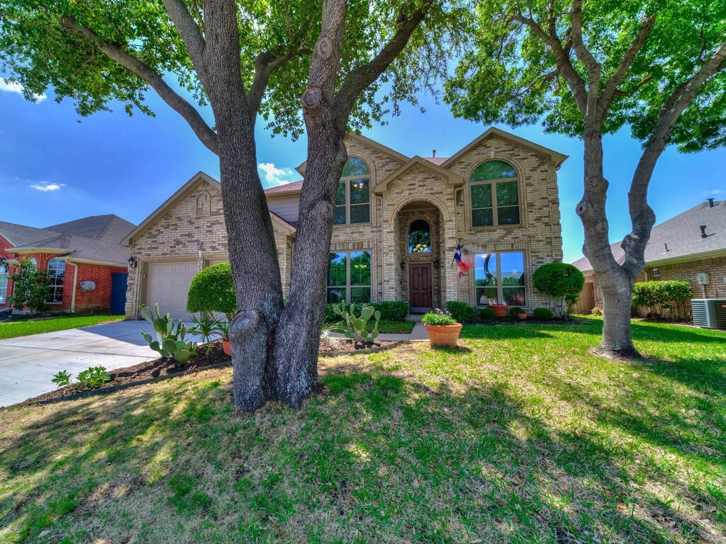 7663 Crosstimbers Ln, North Richland Hills, TX 76182 - traditional-style house with cooling unit, concrete driveway, a front yard, an attached garage, and brick siding