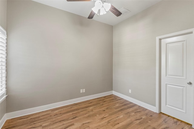 spare room with baseboards, ceiling fan, visible vents, and light wood-type flooring