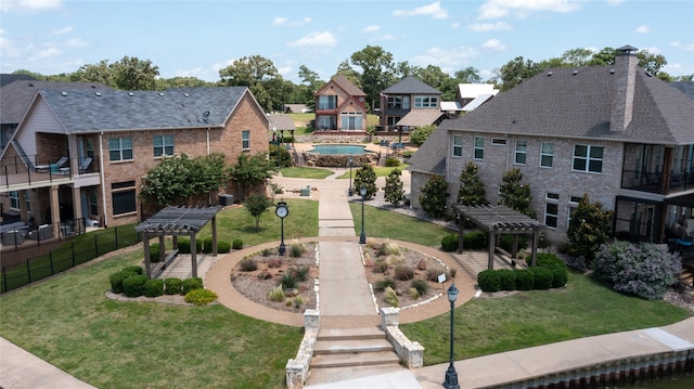 view of home's community with a yard and a pergola
