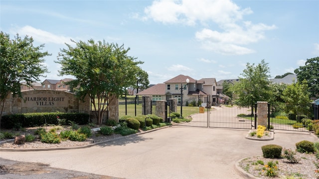 view of street with a residential view, a gated entry, a gate, and curbs