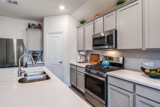 799 Bayberry Ln, Princeton, TX 75407 - kitchen featuring decorative backsplash, light countertops, gray cabinets, a sink, and appliances with stainless steel finishes