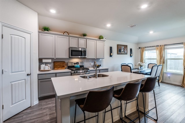799 Bayberry Ln, Princeton, TX 75407 - kitchen featuring a sink, a breakfast bar area, gray cabinets, stainless steel appliances, and wood finished floors