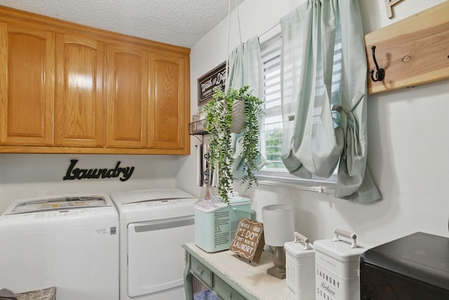 washroom featuring a textured ceiling, independent washer and dryer, and cabinet space