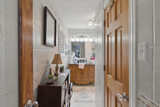 bathroom with vanity, a textured ceiling, and tile patterned floors