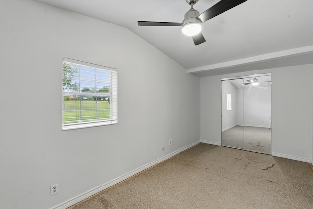unfurnished bedroom featuring carpet flooring, a closet, baseboards, ceiling fan, and vaulted ceiling