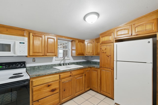 kitchen with light tile patterned floors, brown cabinets, a sink, dark countertops, and white appliances