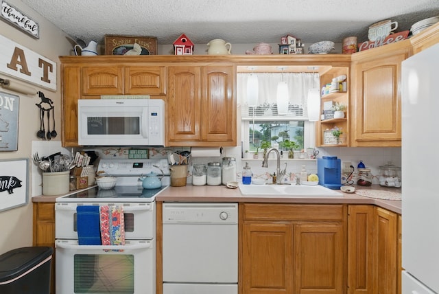 kitchen featuring backsplash, light countertops, a sink, and white appliances