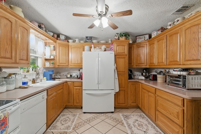 kitchen featuring light tile patterned floors, ceiling fan, white appliances, and visible vents