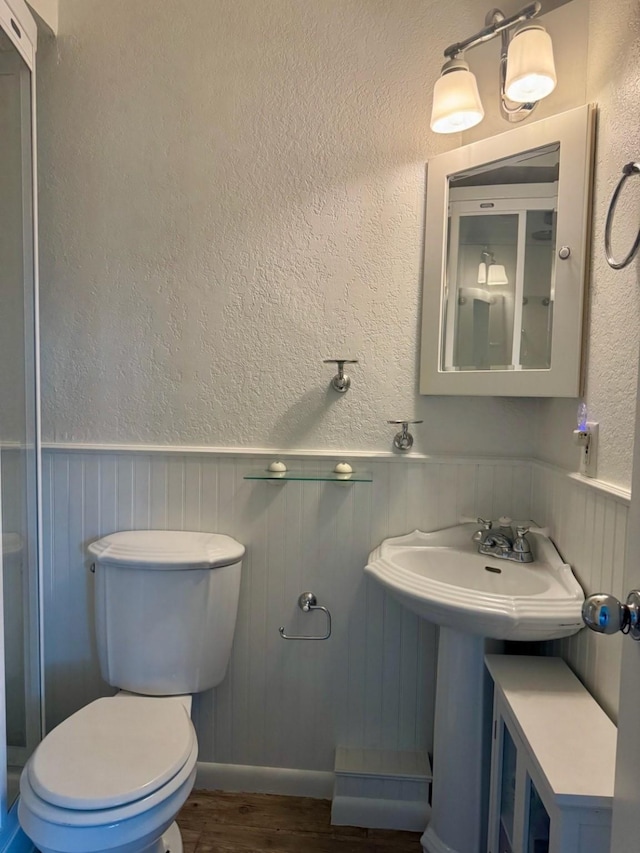 316 Oak Ln, Tool, TX 75143 - bathroom with wainscoting, wood finished floors, and a textured wall