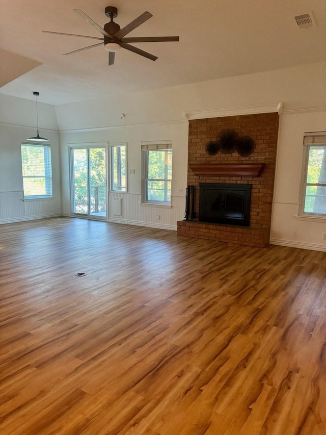 316 Oak Ln, Tool, TX 75143 - unfurnished living room with a brick fireplace, wood finished floors, ceiling fan, lofted ceiling, and wainscoting