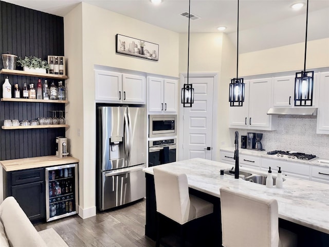 2312 Camp St, Aubrey, TX 76227 - kitchen with stainless steel appliances, beverage cooler, a sink, wood finished floors, and backsplash