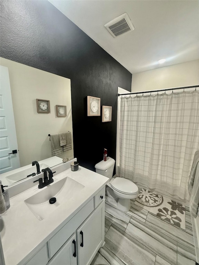 2312 Camp St, Aubrey, TX 76227 - bathroom with toilet, vanity, and a shower with shower curtain