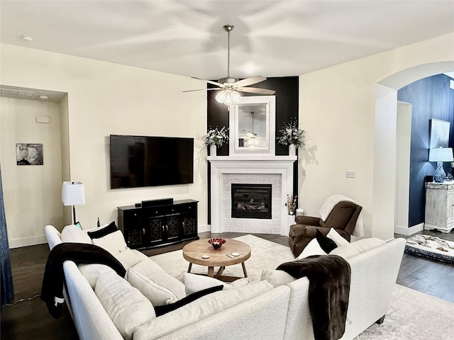 2312 Camp St, Aubrey, TX 76227 - living area with arched walkways, wood finished floors, a glass covered fireplace, and baseboards