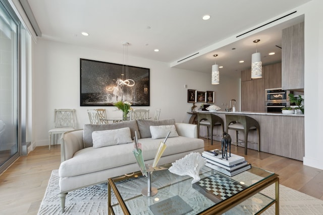 living room with light wood-style flooring, recessed lighting, and baseboards