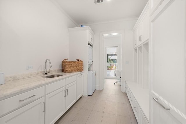 6946 Southridge Dr, Dallas, TX 75214 - bathroom featuring a sink, stacked washer / drying machine, ornamental molding, and tile patterned flooring