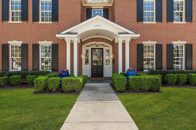 6946 Southridge Dr, Dallas, TX 75214 - view of exterior entry with brick siding and a lawn