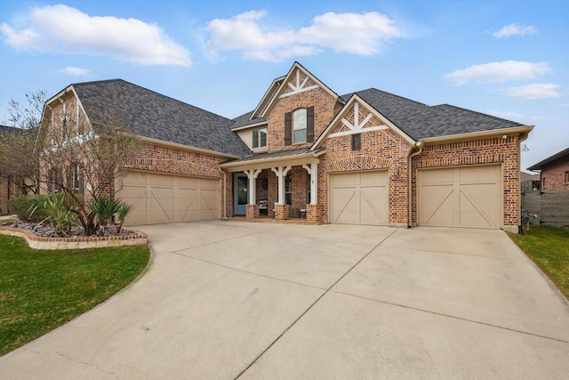 craftsman house with concrete driveway, roof with shingles, an attached garage, a front yard, and brick siding