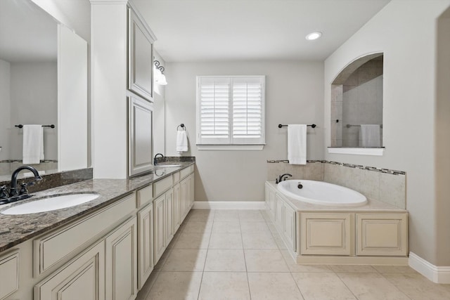 bathroom featuring double vanity, a sink, a garden tub, and tile patterned flooring
