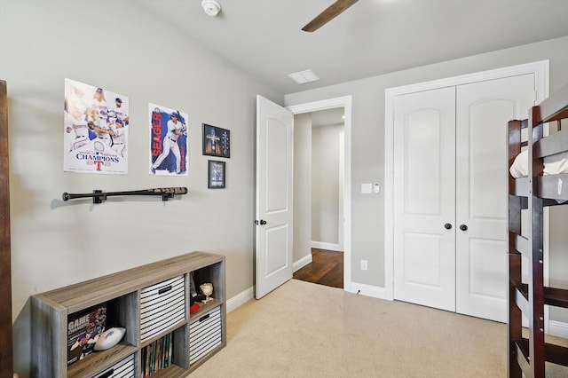 interior space with a ceiling fan, carpet floors, baseboards, and a closet