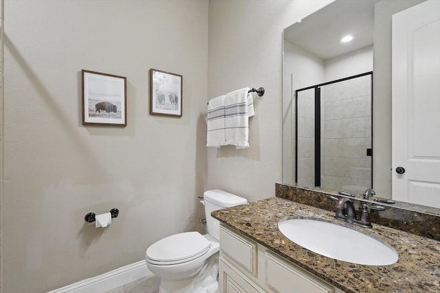 bathroom featuring a stall shower, baseboards, toilet, and vanity