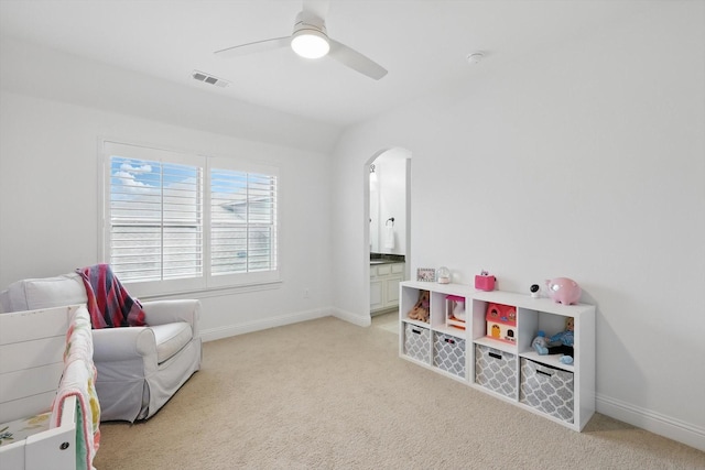 recreation room featuring visible vents, baseboards, ceiling fan, arched walkways, and light colored carpet