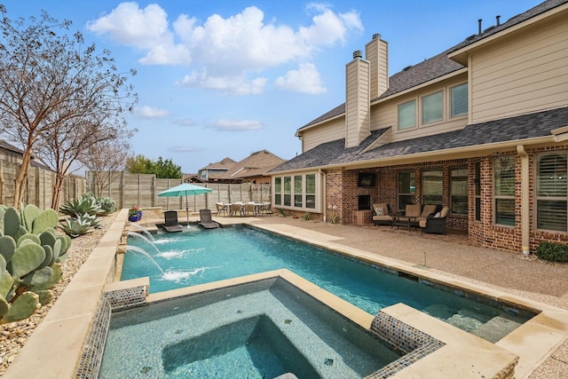 view of swimming pool featuring a fenced backyard, a pool with connected hot tub, and a patio