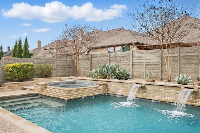 view of pool with a fenced backyard and an in ground hot tub